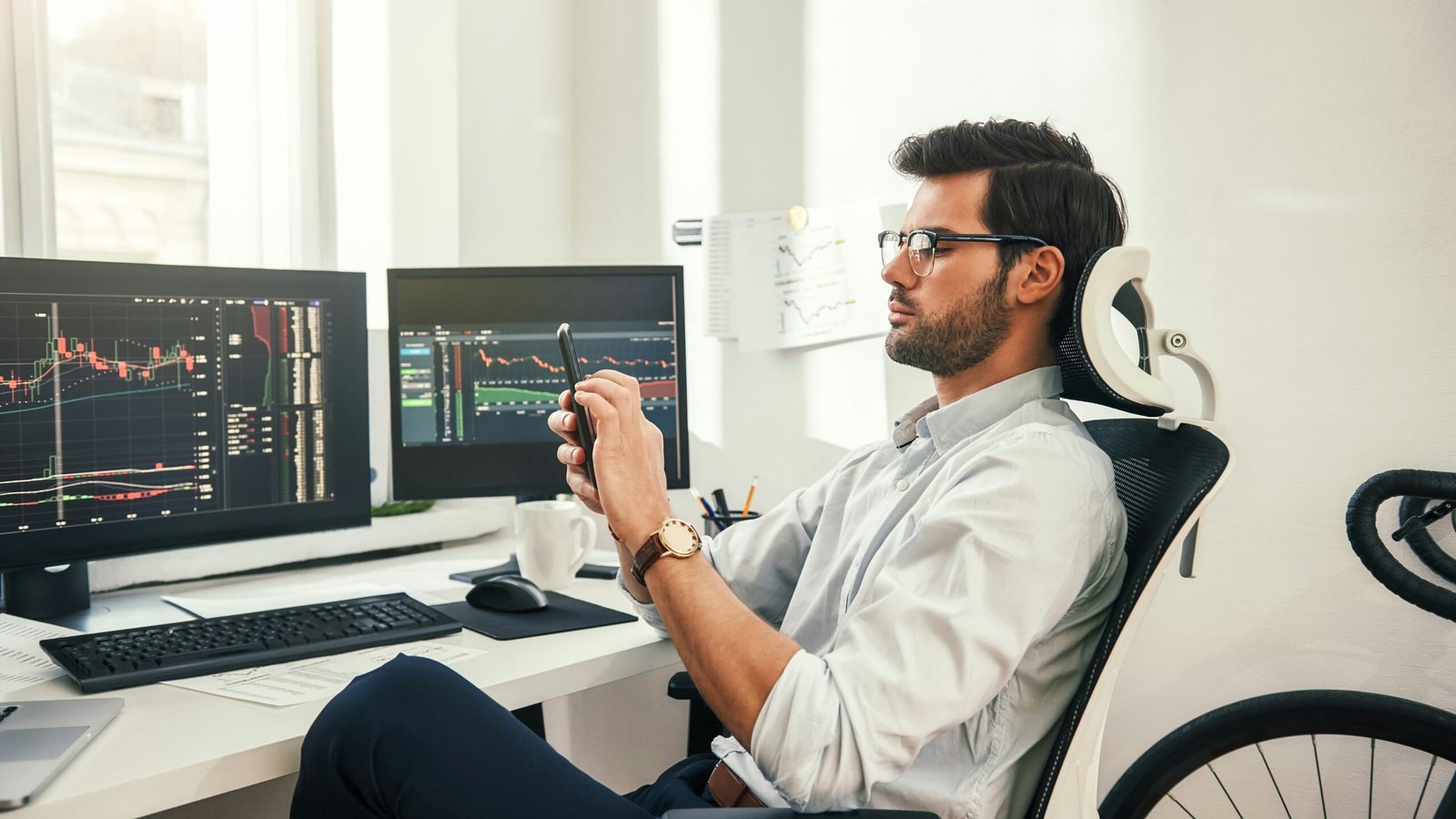 Man in front of his computer screen trading stocks