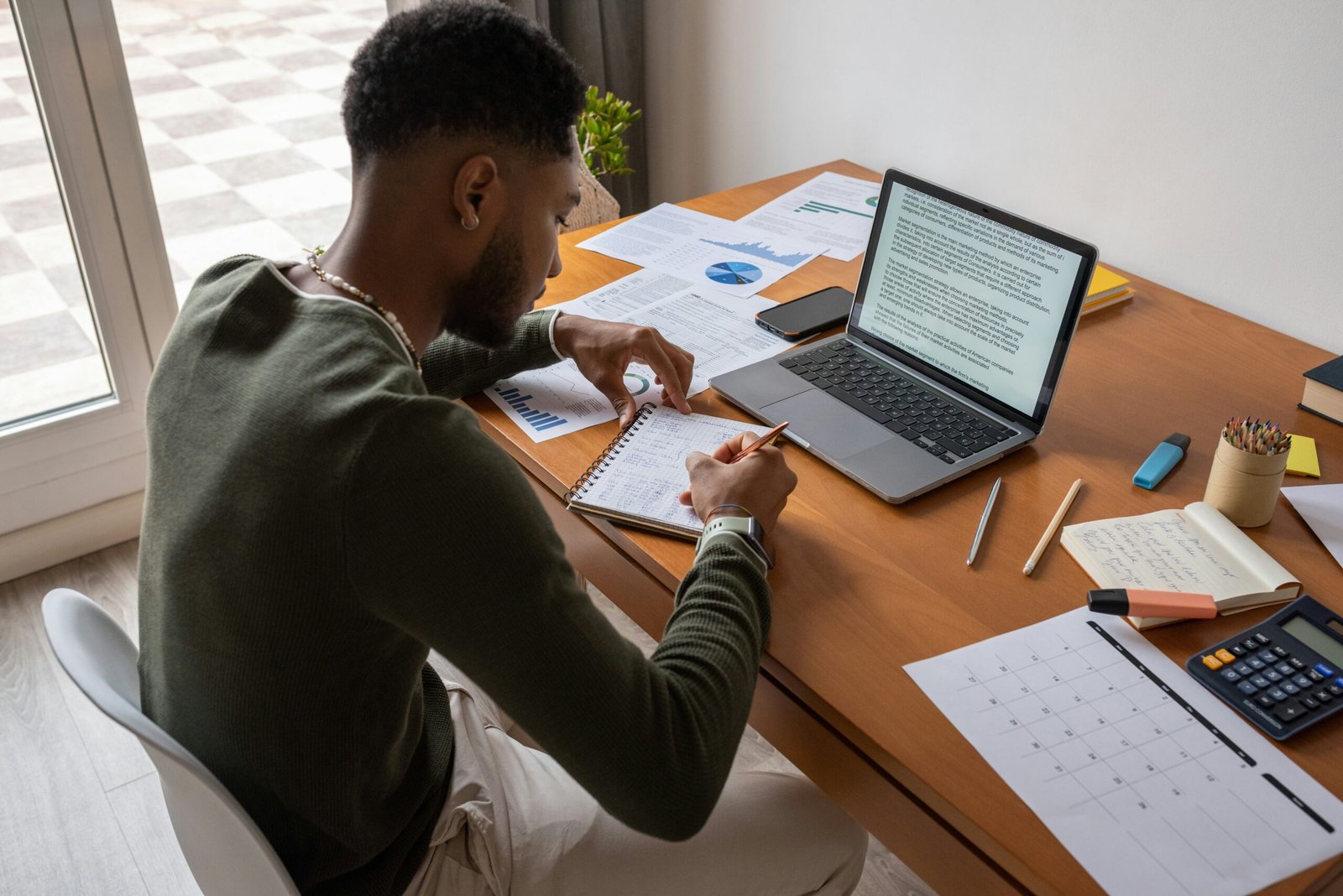 A mixed race man calculating his finances
