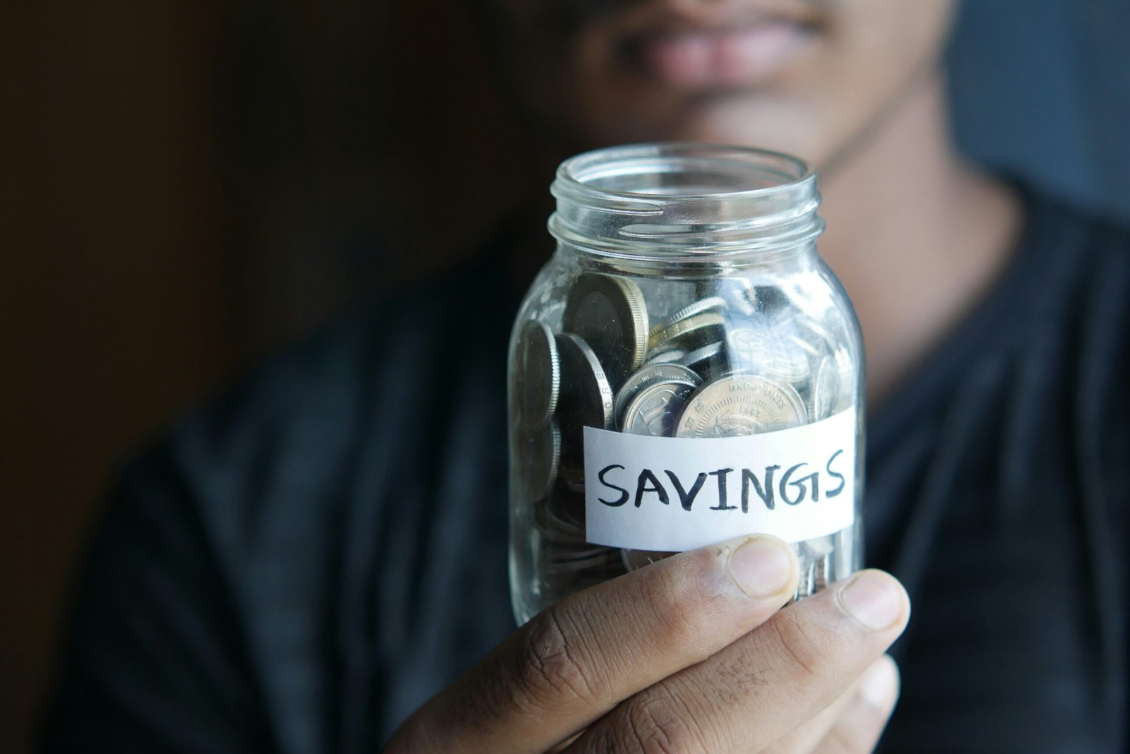 Man holding savings jar